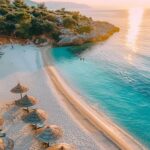 Blick auf Lori Beach Ksamil mit kristallklarem Wasser und sonnigem Himmel